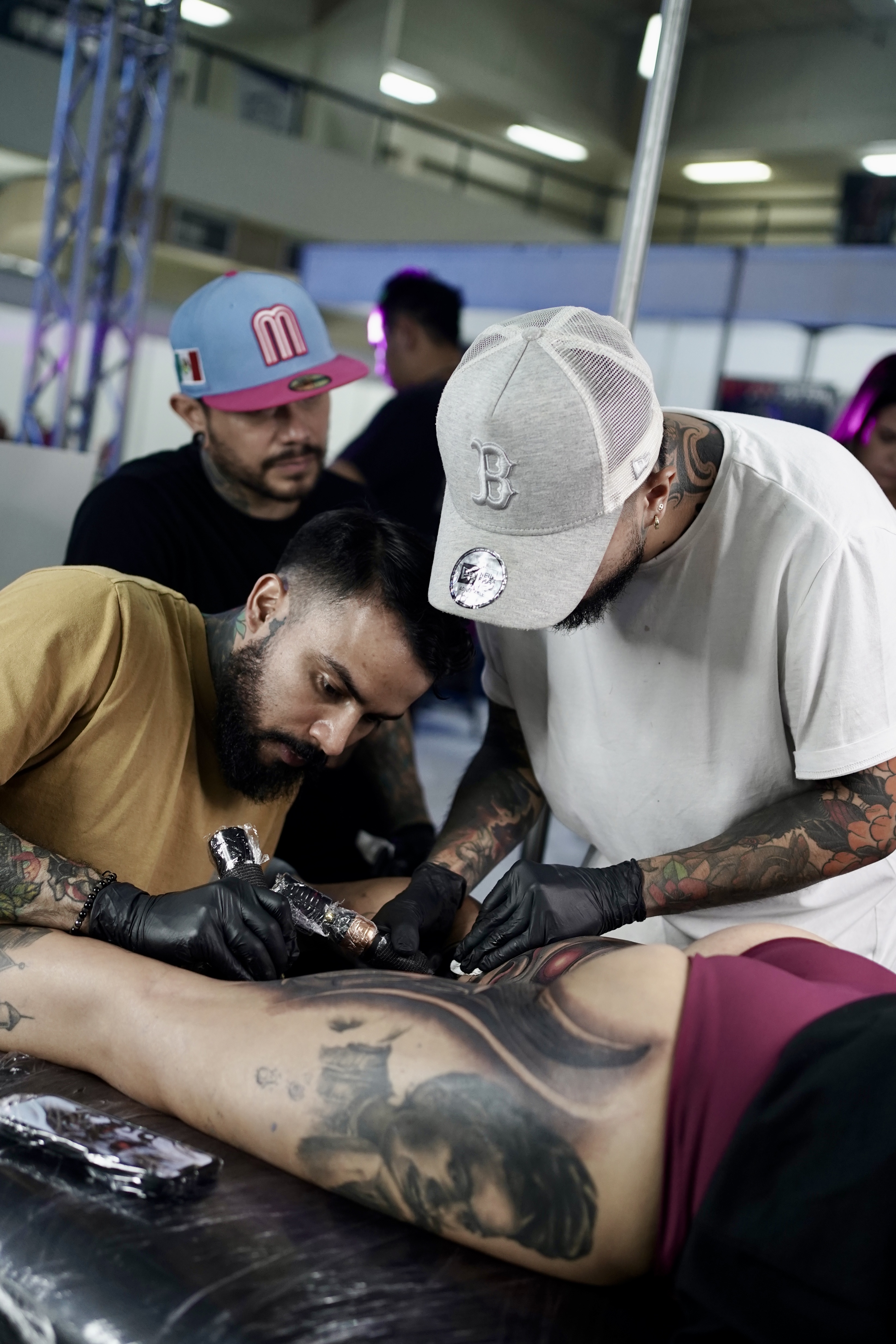 Jose Baena collaborating on a large-scale tattoo with fellow jury members